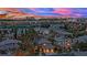 Dusk aerial shot of a luxury home in an upscale neighborhood with city skyline views at 116 N Ring Dove Dr, Las Vegas, NV 89144