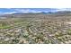 Expansive aerial view of a community with lush landscaping, golf course, and mountain views at 116 N Ring Dove Dr, Las Vegas, NV 89144