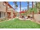 Manicured backyard featuring an outdoor seating area and lush artificial grass at 116 N Ring Dove Dr, Las Vegas, NV 89144