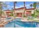Resort-style backyard featuring a pool, spa, multiple lounge areas and mature landscaping at 116 N Ring Dove Dr, Las Vegas, NV 89144