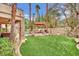 Expansive backyard with lush artificial grass, outdoor seating, and mature landscaping at 116 N Ring Dove Dr, Las Vegas, NV 89144