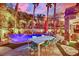 Stunning backyard oasis featuring a pool, patio with dining, and lush landscaping at twilight at 116 N Ring Dove Dr, Las Vegas, NV 89144
