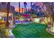 Stunning backyard oasis with lush turf, a pool, and lounge area perfect for relaxing and entertaining at 116 N Ring Dove Dr, Las Vegas, NV 89144