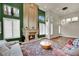Inviting living room with a cozy fireplace, large windows, and stylish decor at 116 N Ring Dove Dr, Las Vegas, NV 89144