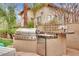 Outdoor kitchen featuring a built-in grill, pizza oven, and stainless steel refrigerator at 116 N Ring Dove Dr, Las Vegas, NV 89144