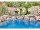 Beautiful pool with a stone waterfall feature and lush tropical landscaping at 116 N Ring Dove Dr, Las Vegas, NV 89144