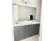 Modern bathroom featuring double vanity with gray cabinets, quartz countertops, and a large mirror at 11703 Emerald Lake Ave, Las Vegas, NV 89138