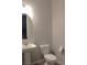 Cozy half bathroom featuring pedestal sink, toilet, mirror, and neutral walls at 11703 Emerald Lake Ave, Las Vegas, NV 89138