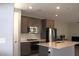Modern kitchen showcasing gray cabinets, stainless steel appliances, and center island with quartz countertops at 11703 Emerald Lake Ave, Las Vegas, NV 89138