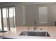 Kitchen island featuring a stainless steel sink, modern faucet, and view of the backyard patio through sliding glass doors at 11703 Emerald Lake Ave, Las Vegas, NV 89138
