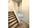 Carpeted staircase with white railing leading to upper level, neutral walls, and natural light at 11703 Emerald Lake Ave, Las Vegas, NV 89138