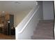 Carpeted staircase with white railing leading to upper level, adjacent to a modern kitchen area at 11703 Emerald Lake Ave, Las Vegas, NV 89138