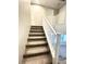 Carpeted staircase with white railing leading to upper level, neutral walls, and natural light at 11703 Emerald Lake Ave, Las Vegas, NV 89138
