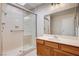 Bathroom with glass-enclosed shower, grab bar, sink with wooden cabinet and a skylight at 1813 Pluto Dr, Las Vegas, NV 89108