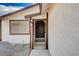Inviting home entrance with a classic dark-colored door, textured walls and landscaped gravel at 1813 Pluto Dr, Las Vegas, NV 89108