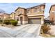 Two-story home with tan stucco, desert landscaping, a driveway, and an attached two-car garage at 1930 Silver Crest Ct, North Las Vegas, NV 89031