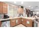 Spacious kitchen with wood cabinets, stainless steel dishwasher, and an adjacent dining area at 1930 Silver Crest Ct, North Las Vegas, NV 89031