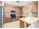 Traditional kitchen features tile countertops, stainless steel appliances, and wooden cabinets at 1930 Silver Crest Ct, North Las Vegas, NV 89031