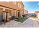 A backyard patio boasts stone pavers, furniture, and artificial turf, ideal for outdoor entertaining and relaxation at 1930 Silver Crest Ct, North Las Vegas, NV 89031