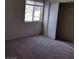 This bedroom features neutral carpet, a window, and a closet with sliding doors at 2110 Los Feliz St # 2037, Las Vegas, NV 89156