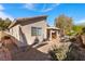 Exterior view of the backyard featuring desert landscaping and a covered patio at 2137 Hidden Ranch Ter, Henderson, NV 89052