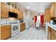 Eat-in kitchen featuring appliances, light wood cabinetry, and tile floors for a modern aesthetic at 2137 Hidden Ranch Ter, Henderson, NV 89052