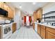 Kitchen boasts an open layout with appliances, light wood cabinetry, and bright tile floors, perfect for cooking at 2137 Hidden Ranch Ter, Henderson, NV 89052