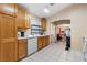 Well-lit kitchen featuring wooden cabinets, white appliances, and tiled flooring, flowing seamlessly into the dining area at 2137 Hidden Ranch Ter, Henderson, NV 89052