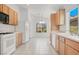 Bright kitchen with white appliances, wood cabinets, and access to breakfast nook at 2137 Hidden Ranch Ter, Henderson, NV 89052