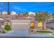 Charming single-story home featuring a stone facade, desert landscaping and a two-car garage at 2475 Hamonah Dr, Henderson, NV 89044