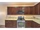 Beautiful dark wood kitchen cabinets, stainless appliances and granite countertops at 2475 Hamonah Dr, Henderson, NV 89044