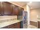 Kitchen featuring stainless steel refrigerator, granite countertops and dark wood cabinets at 2475 Hamonah Dr, Henderson, NV 89044
