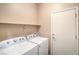Bright laundry room includes a washer, dryer, and convenient overhead shelving at 2475 Hamonah Dr, Henderson, NV 89044