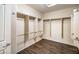 This walk-in closet features a wood floor and several shelving units with hanging rods at 2475 Hamonah Dr, Henderson, NV 89044