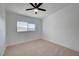 Carpeted bedroom with a large window offering outside view and a modern ceiling fan at 2512 Taylor Ave, North Las Vegas, NV 89030