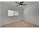 Bedroom featuring neutral carpet, block wall, ceiling fan, and natural light from a large window at 2512 Taylor Ave, North Las Vegas, NV 89030