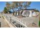 Well-maintained home with white picket fence, mature trees, and low-maintenance gravel landscaping at 2512 Taylor Ave, North Las Vegas, NV 89030