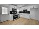Modern kitchen boasts white cabinetry, stainless steel appliances, and sleek black backsplash at 2512 Taylor Ave, North Las Vegas, NV 89030