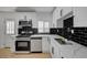 Updated kitchen features white cabinets, stainless steel appliances, and sleek black subway tile backsplash at 2512 Taylor Ave, North Las Vegas, NV 89030