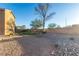 Backyard featuring gravel, desert landscaping, home exterior, and stone retaining wall at 2681 Benton Cove St, Laughlin, NV 89029