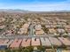 Expansive aerial view showcases a residential community with terracotta rooftops, lush trees, and mountain range in the distance at 2765 Struan, Henderson, NV 89044