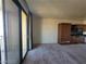 Open living room with sliding doors to balcony and kitchenette space with brown cabinetry at 29 Montelago Blvd # 336, Henderson, NV 89011