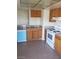 A well-lit kitchen featuring tile flooring, oak cabinets, and light granite countertops at 2981 Country Manor Ln # 118, Las Vegas, NV 89115