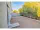 Exterior of home overlooking low-maintenance backyard gravel, block fence, and lush greenery at 3236 Idaho Springs St, North Las Vegas, NV 89032