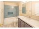 Bathroom with blue tiled shower over tub and sleek vanity with white countertop at 3725 Shanagolden St, Las Vegas, NV 89129
