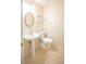 Clean half bathroom featuring a pedestal sink, toilet, and neutral tile flooring at 3725 Shanagolden St, Las Vegas, NV 89129