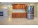 Kitchen featuring stainless steel refrigerator, wooden cabinets and white countertop, and tile flooring at 3725 Shanagolden St, Las Vegas, NV 89129