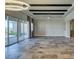 Bright living room featuring tile floors, decorative ceiling beams, and glass sliding doors at 3914 Jacob Lake Cir, Las Vegas, NV 89118