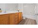Bright bathroom features double vanity, wood cabinets, and tub with white tile surround at 4305 Morgan Manor St # 3, North Las Vegas, NV 89032