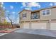 Three-story townhome featuring a balcony, three garage doors, and neutral color palette at 4305 Morgan Manor St # 3, North Las Vegas, NV 89032